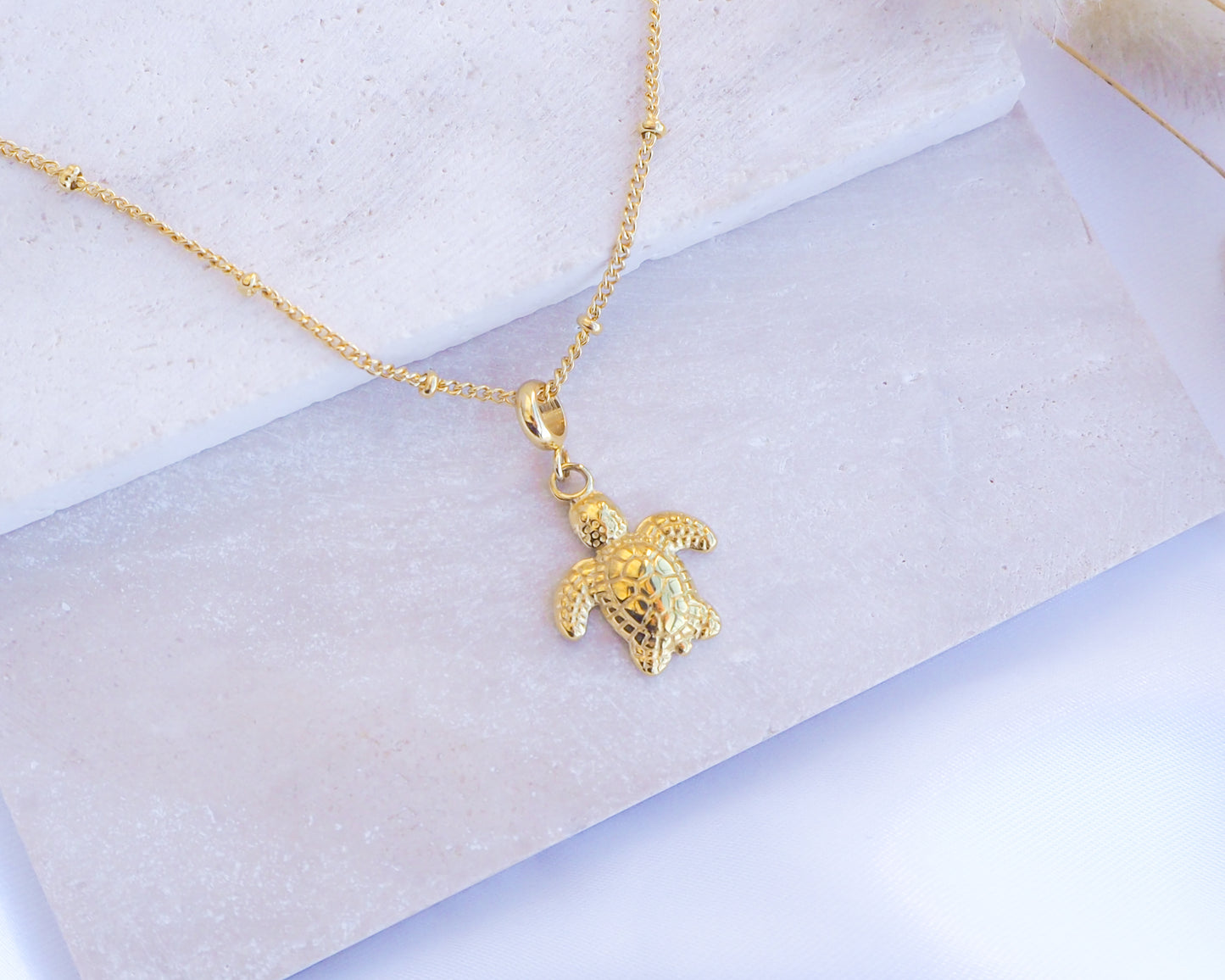 Gold Baby Turtle Necklace on stone, sea turtle necklace