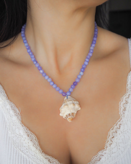 Model wearing Red-mouthed Dog Winkle Shell with Angelite Gemstone Necklace on neck, Blue gemstone bead necklace with off white big conch shell