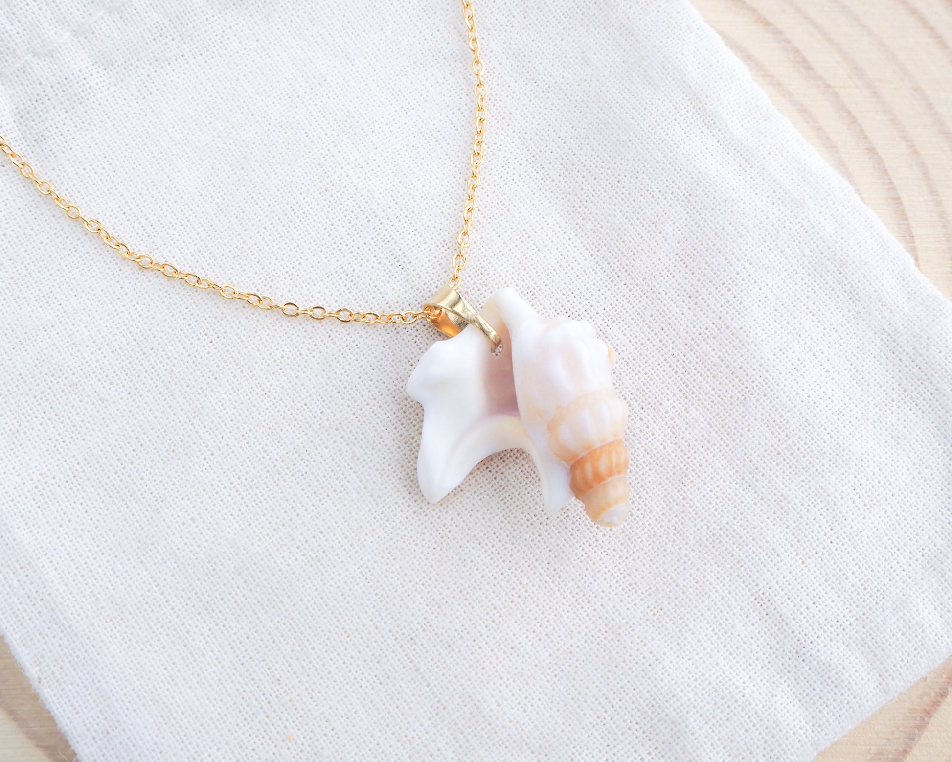 Brown Pelicans Foot Shell Gold Necklace backside on display