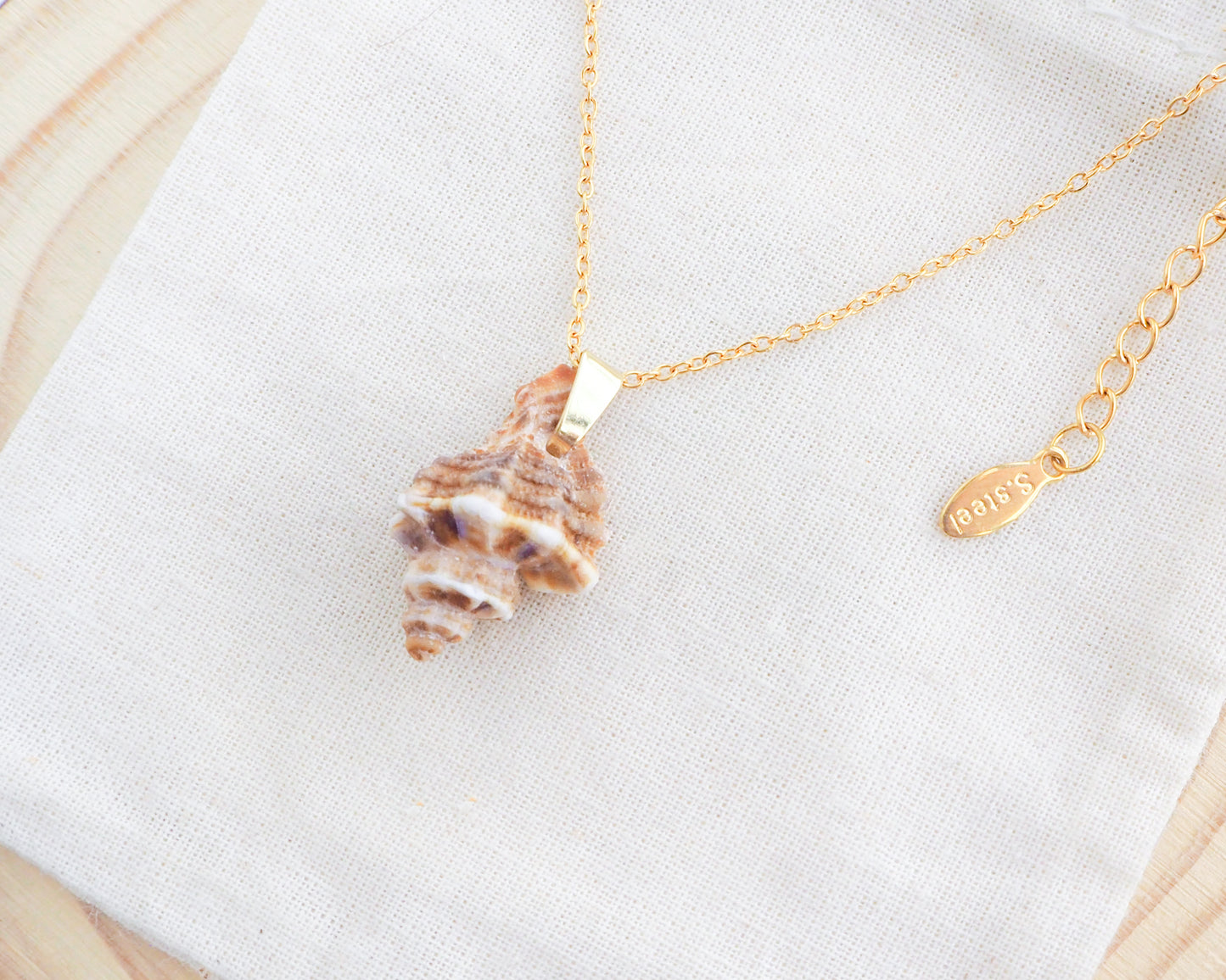 Brown Sting Winkle Gold Necklace side view on display