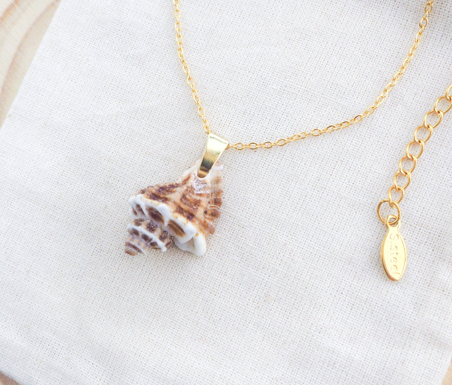 Gold Brown White Sting Winkle Necklace on display