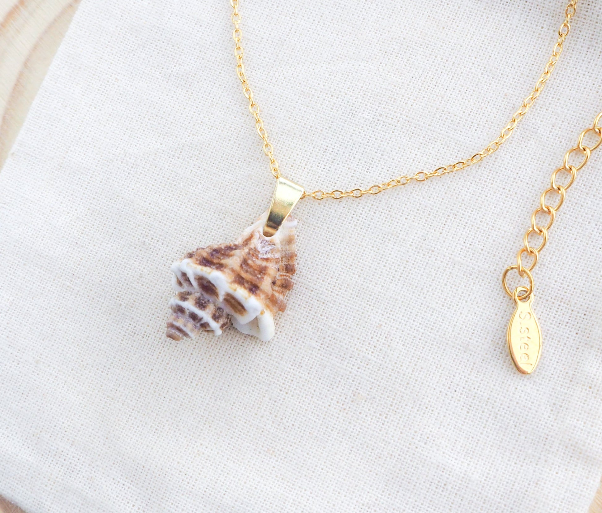 Gold Brown White Sting Winkle Necklace on display
