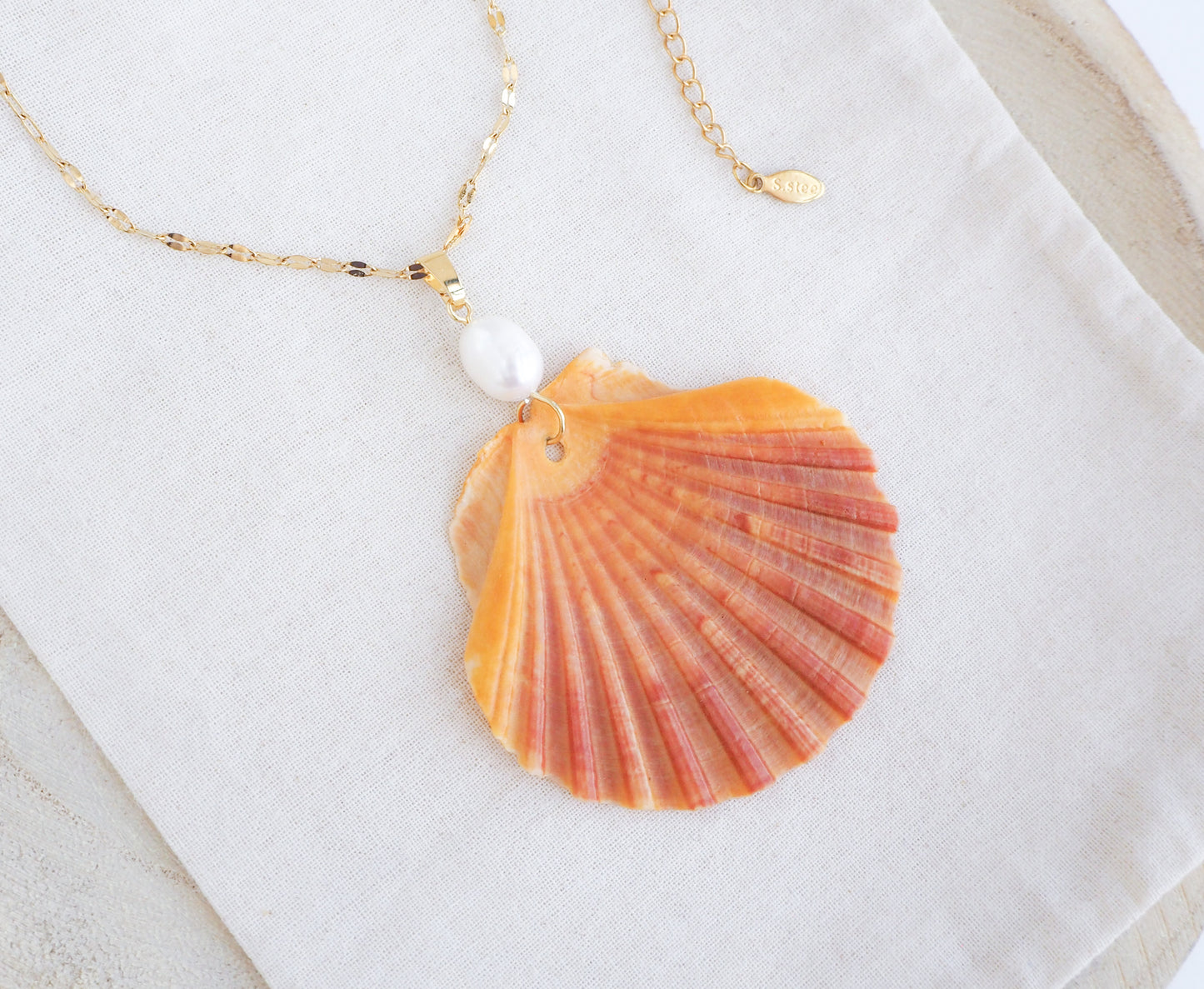 Coral Orange Scallop Shell Pearl Gold Necklace on display, Pilgrims Scallop Shell from Portugal with freshwater pearl and gold chain.