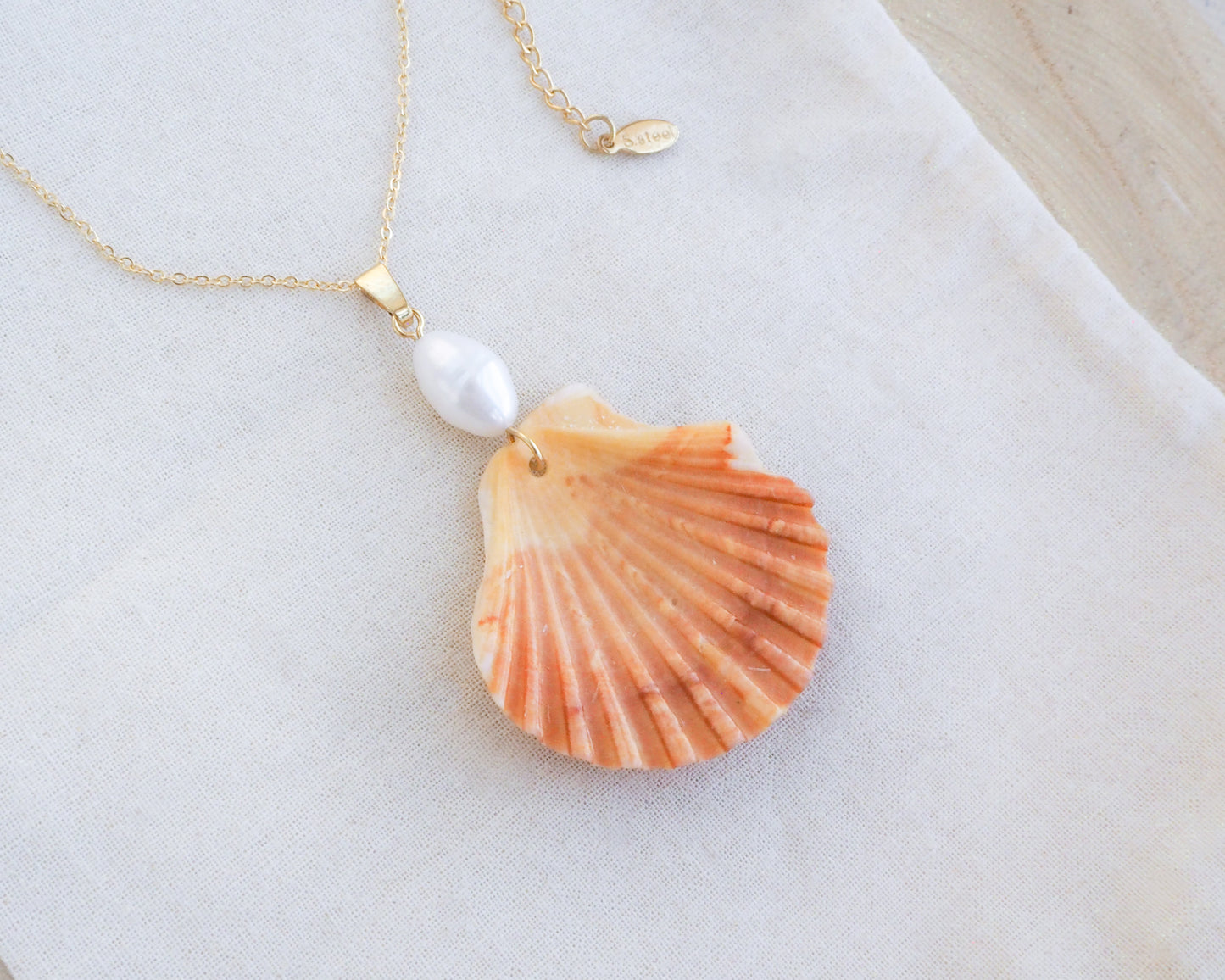 Coral Orange Scallop Shell Pearl Gold Necklace IV on display, Pilgrims Scallop Shell from Portugal with freshwater pearl and gold chain.