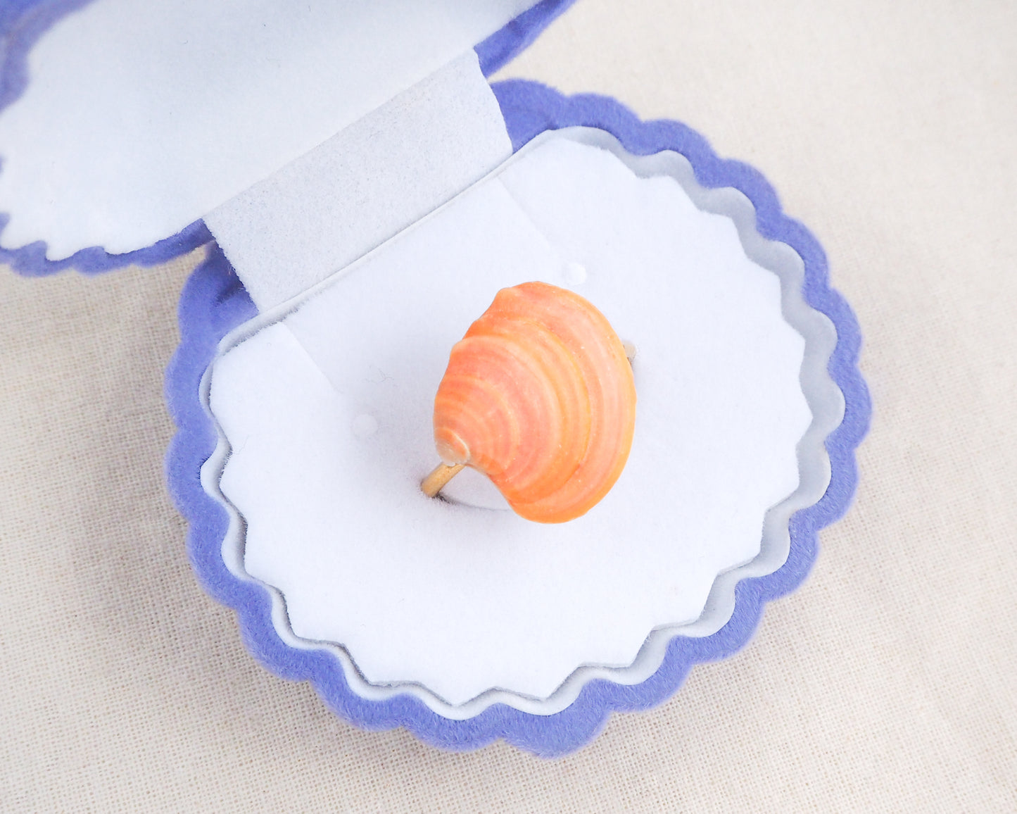 Coral Orange Shell Ring from Portugal displayed on stone front view, colorful orange shell gold ring