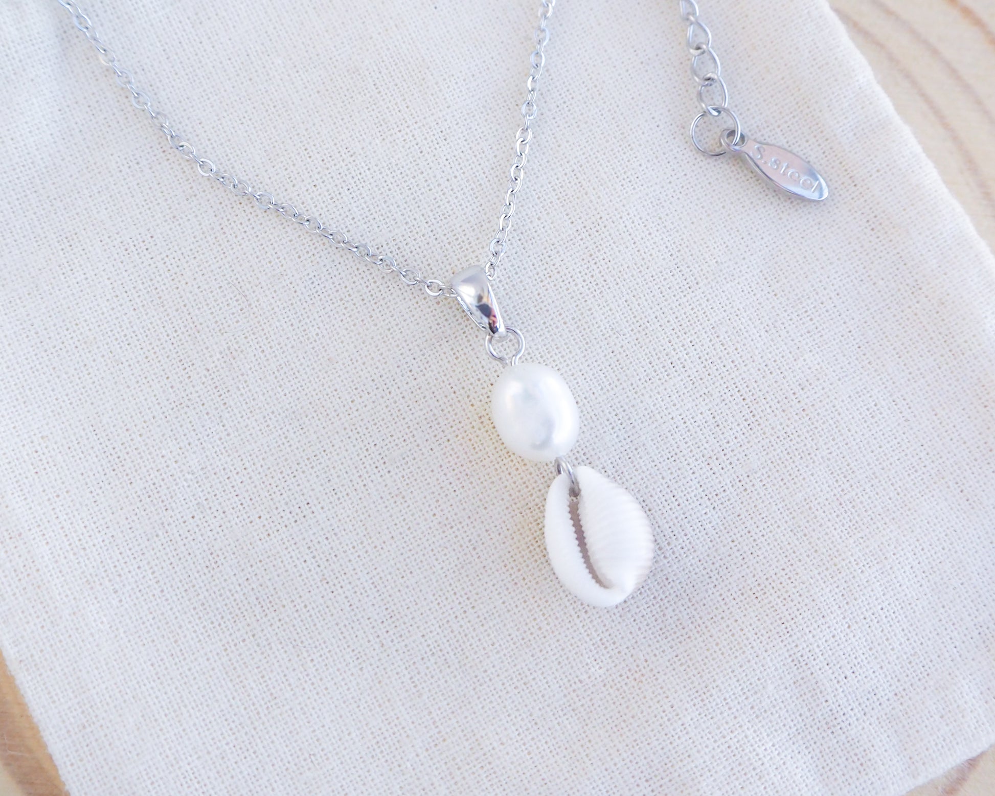 Cowrie Shell Pearl Silver Necklace on display