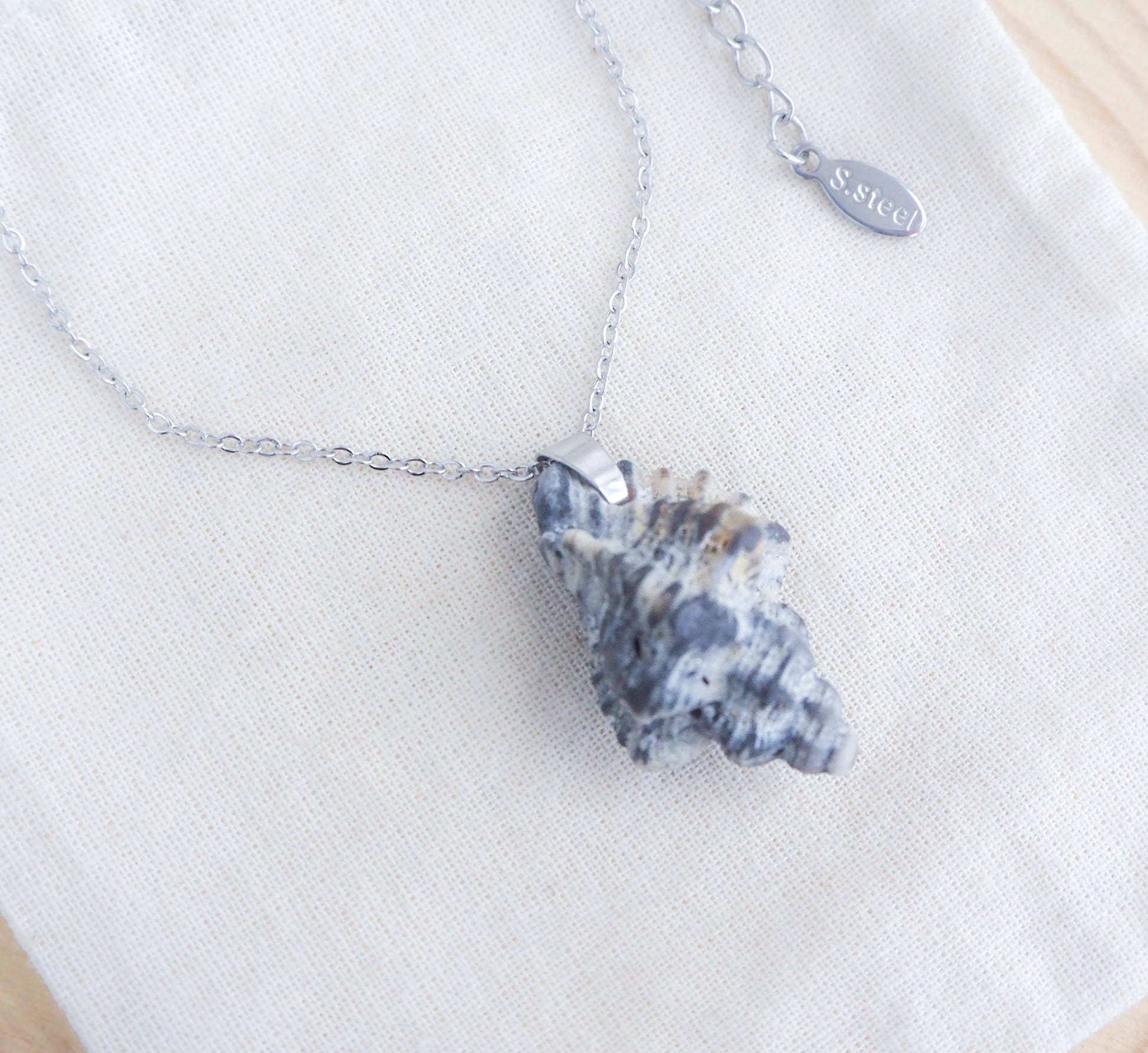 Dark Grey Sting Winkle Shell Necklace on display