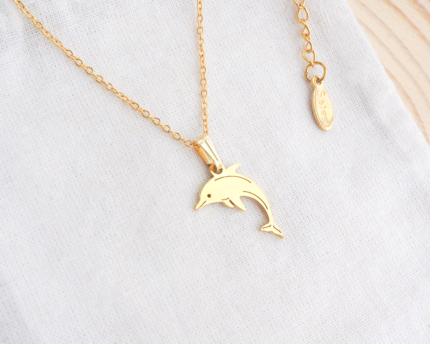 Dolphin Minimalistic Necklace made with 14k gold on display