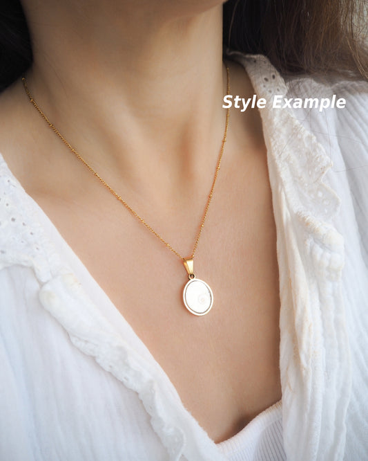 Example of White Eye of Saint Lucia Gold Necklace on neck of model, 18k gold stainless steel shiva eye pendant necklace, Saint Lucy Eye, operculum pendant