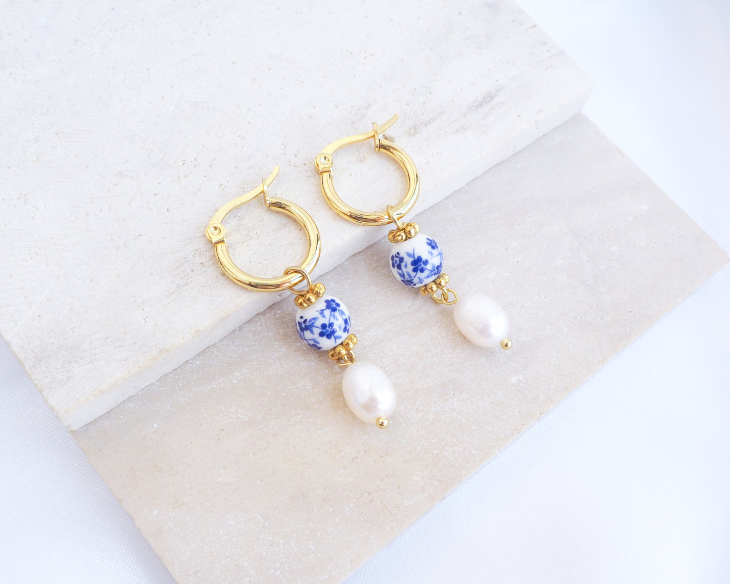 Front view of Gold Azulejo Pearl Earrings from Portugal on stone displayed, Lisbon Tile Jewelry, Portuguese memory holiday gift.