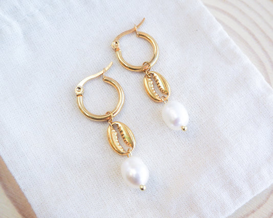 Gold cowrie shell earrings with freshwater pearls on displayed