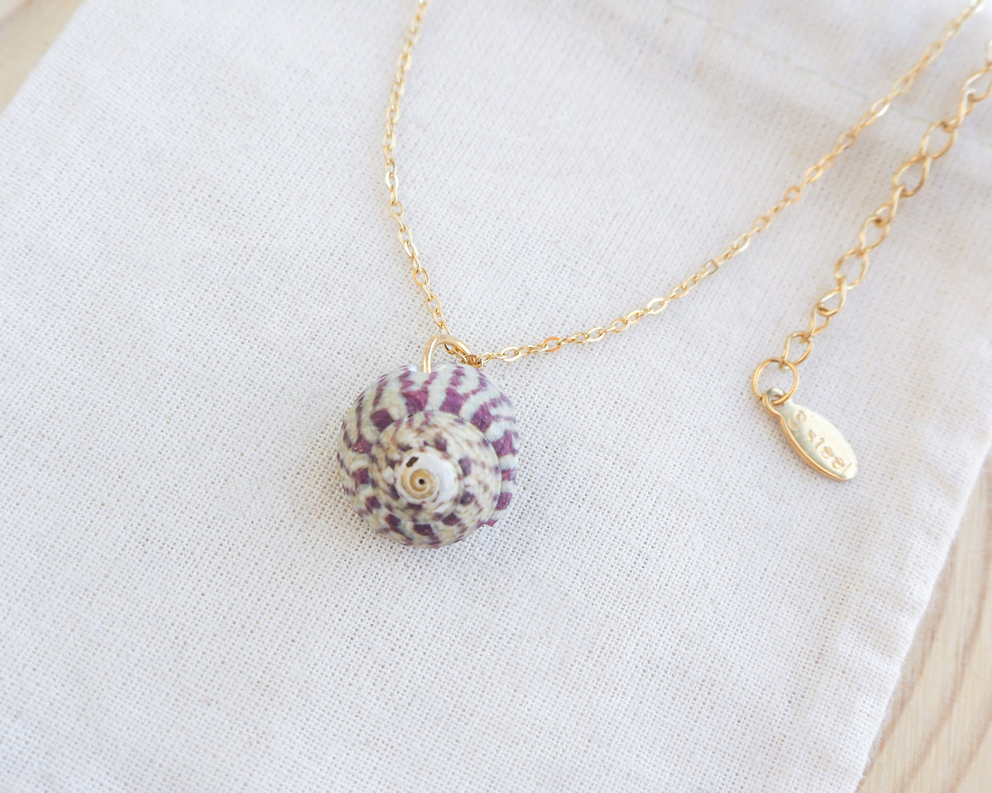 Fuchsia Green Striped Top Shell Necklace on display, with gold stainless steel chain. Real shell necklace from Portugal.