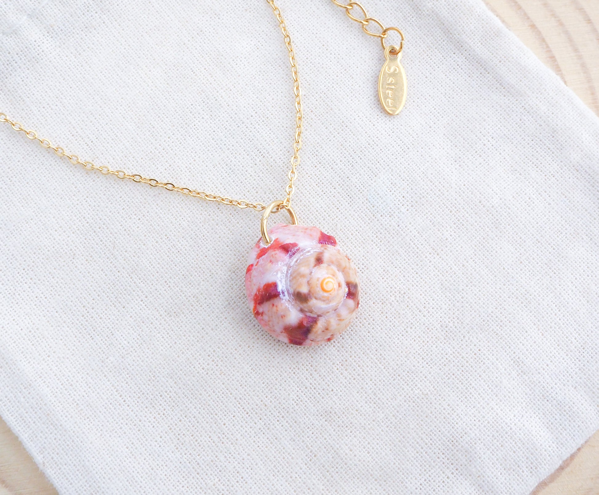 Gold Fuchsia Pink Magus Top Shell Necklace on display
