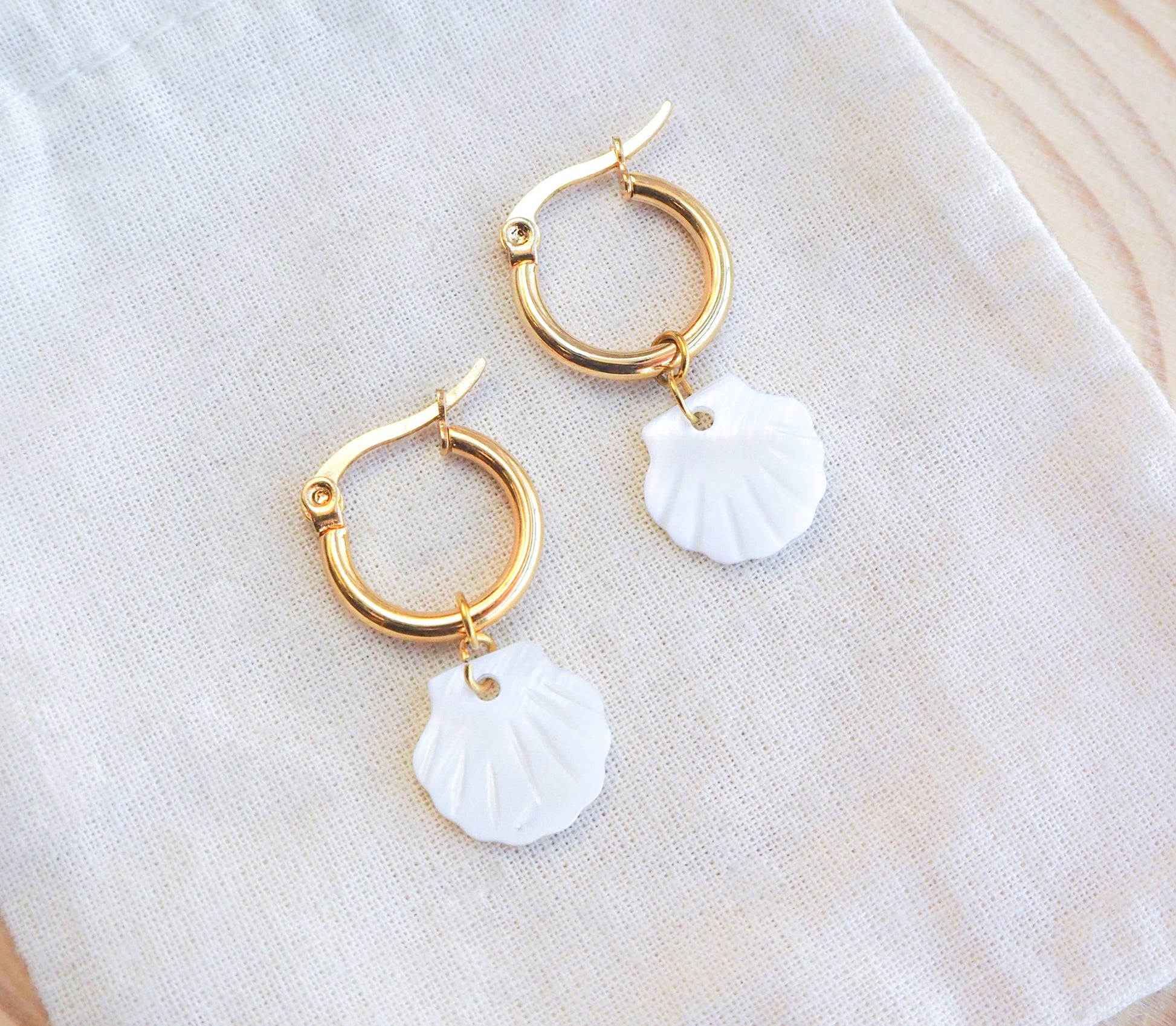 Gold Mother of Pearl Earrings on display, gold hoop earrings with mother-of-pearl shell pendants