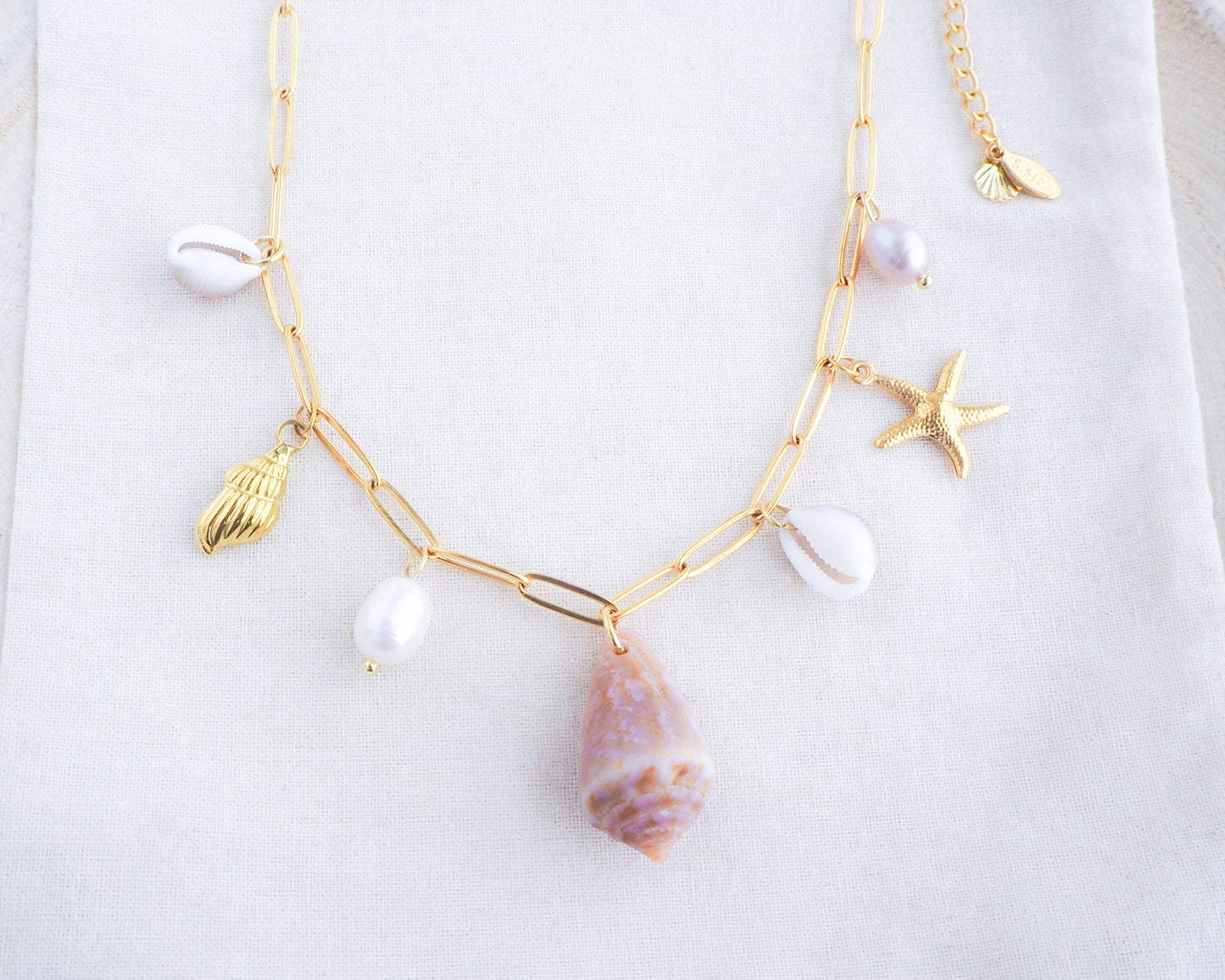 Gold Ocean Shell Charm Necklace detailed view, with cone and cowrie shells, freshwater pearls, starfish sea star shell pendants.