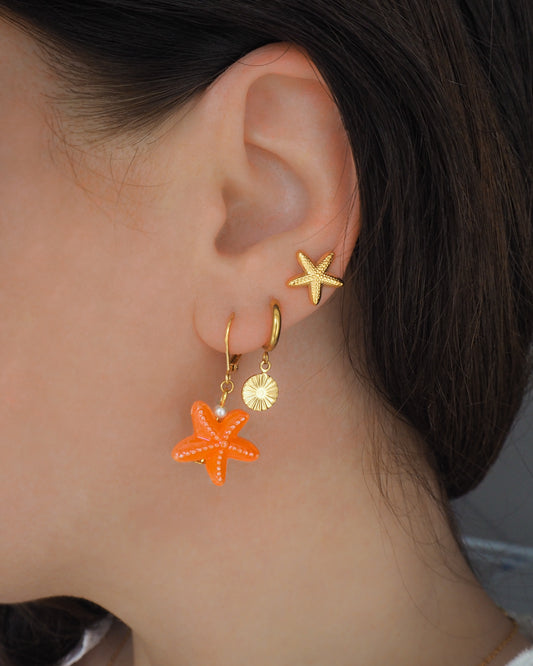 Gold Orange Ceramic Starfish Sea Star Earring in ear model with gold starfish stud earrings