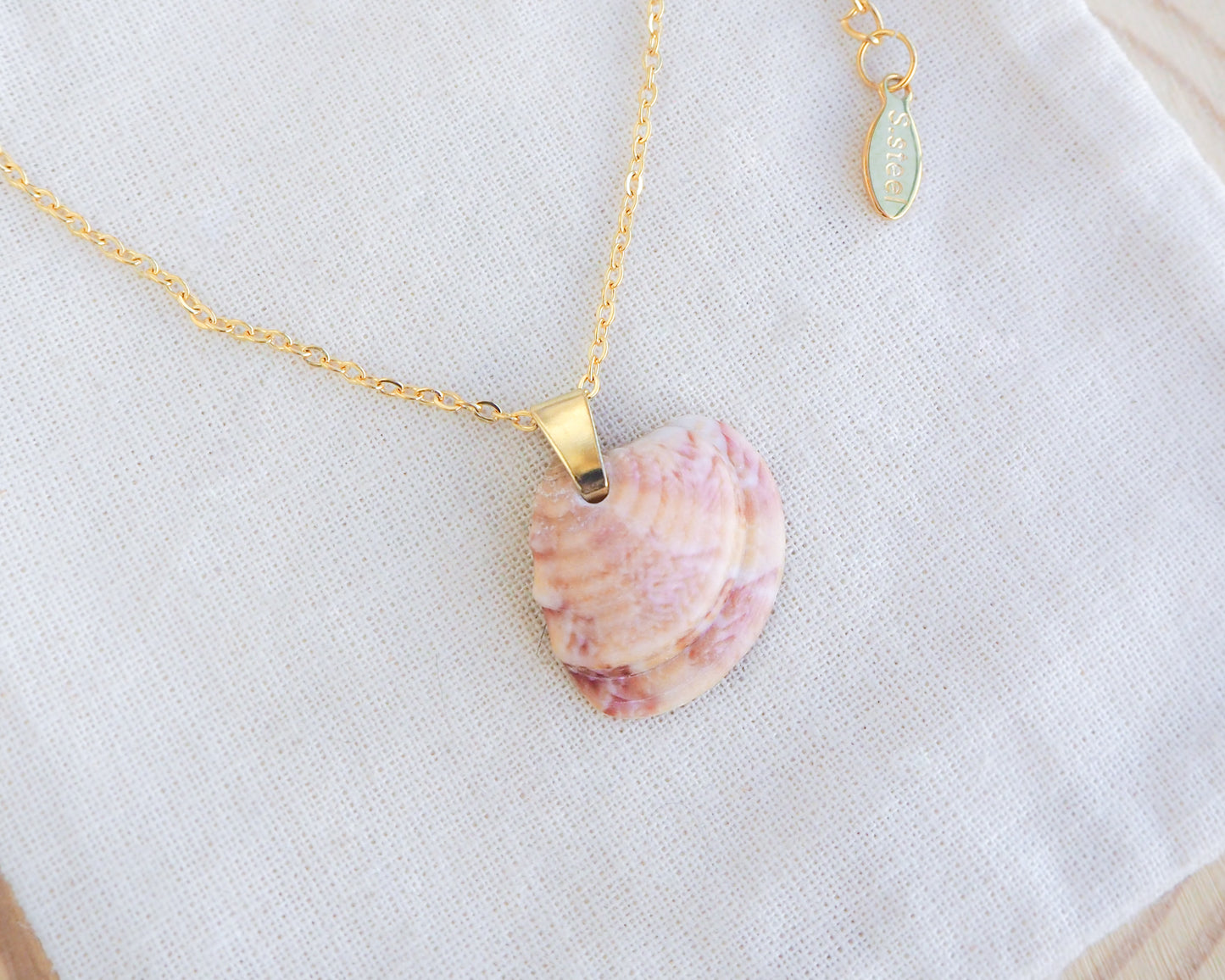 Gold Orange Coral Venus Shell Necklace on display