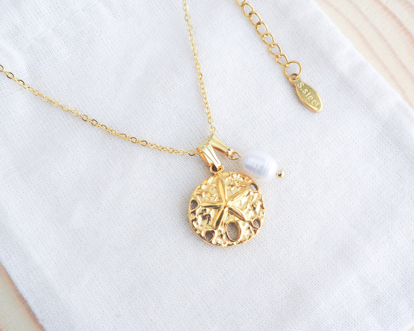 Gold Sand Dollar White Freshwater Pearl Necklace on display