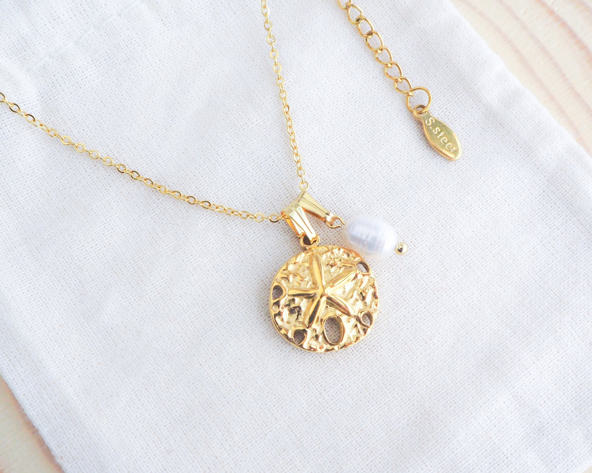 Gold Sand Dollar White Freshwater Pearl Necklace on display