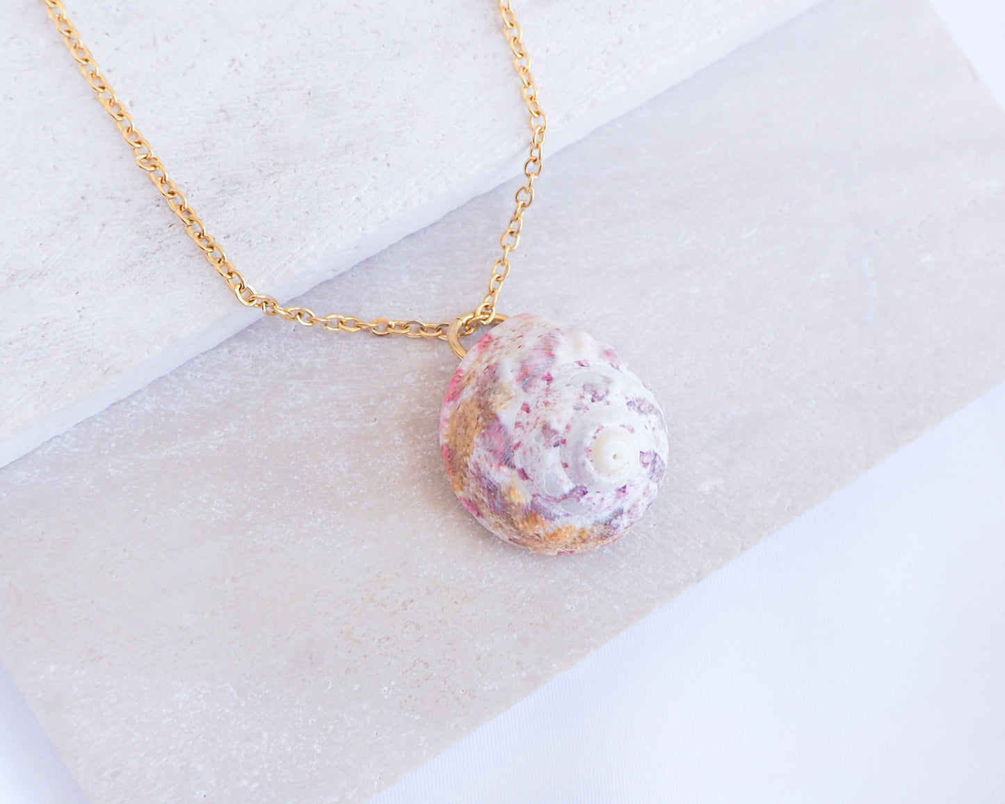 Sunny Pink White Orange Magus Top Shell Gold Necklace on stone display side view