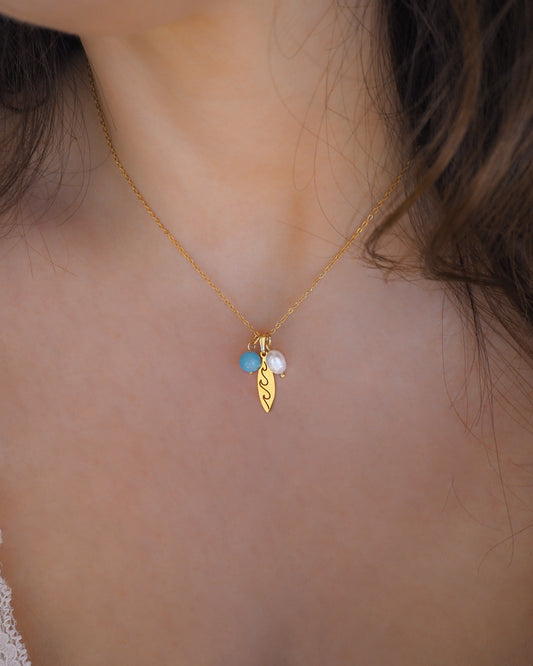 Gold Surfboard Necklace with Freshwater Pearl & Aquamarine Beads on model