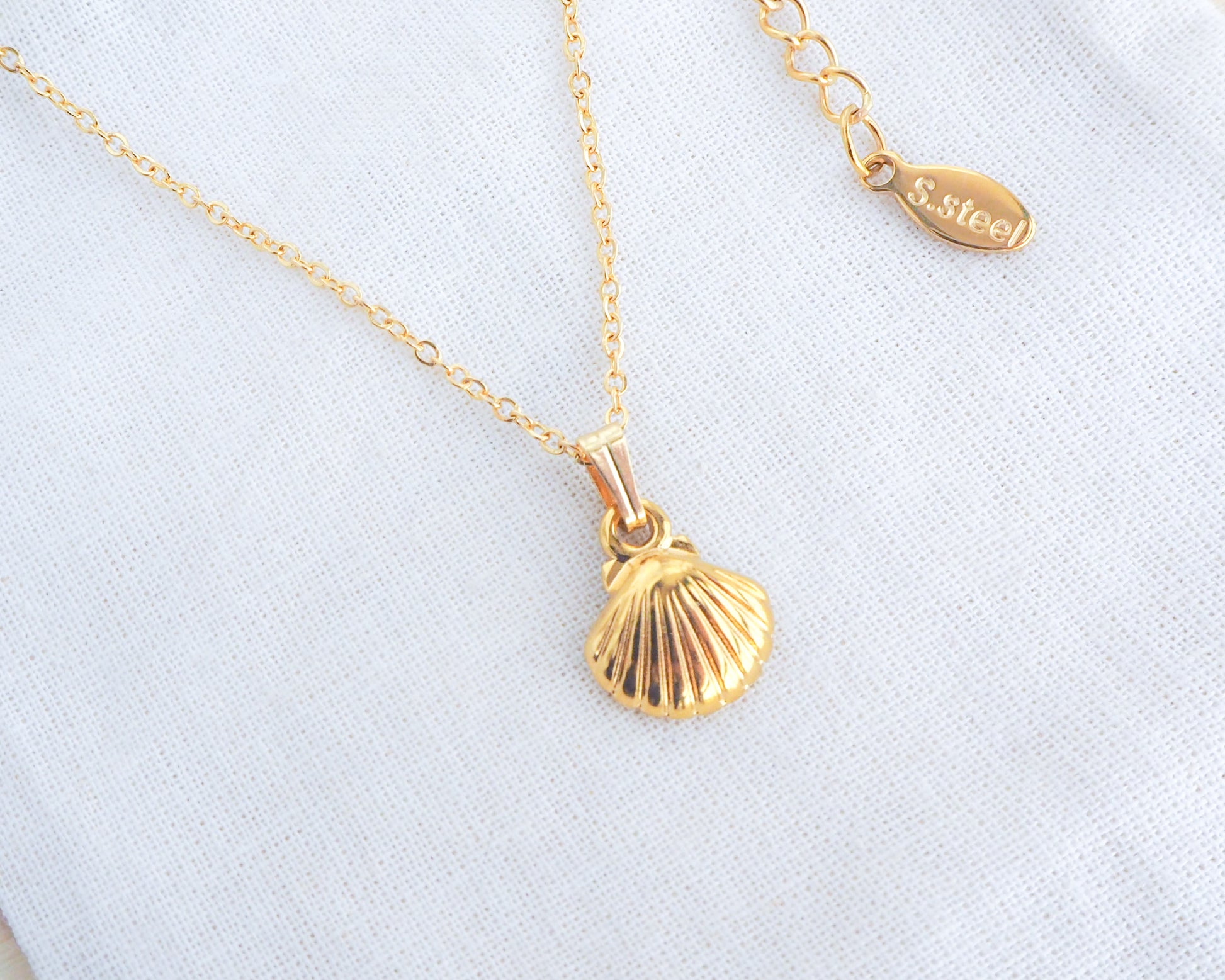 Gold tiny shell pendant close up classic clasp