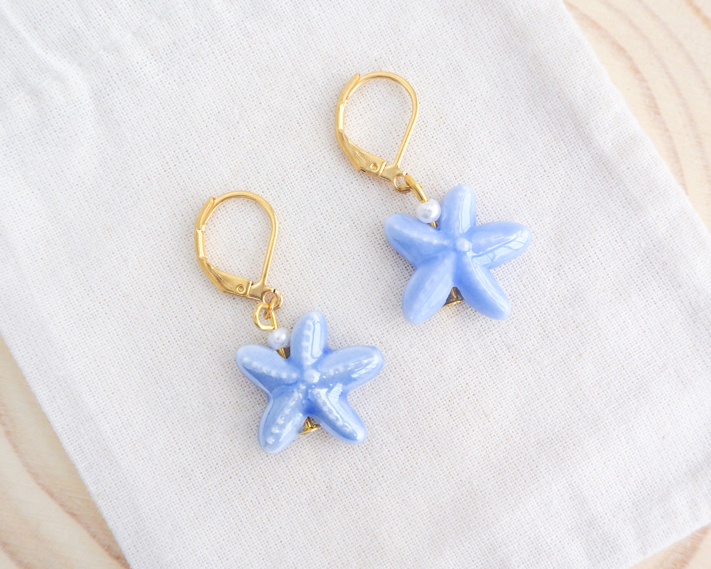 Light Blue Starfish Ceramic Earrings on display