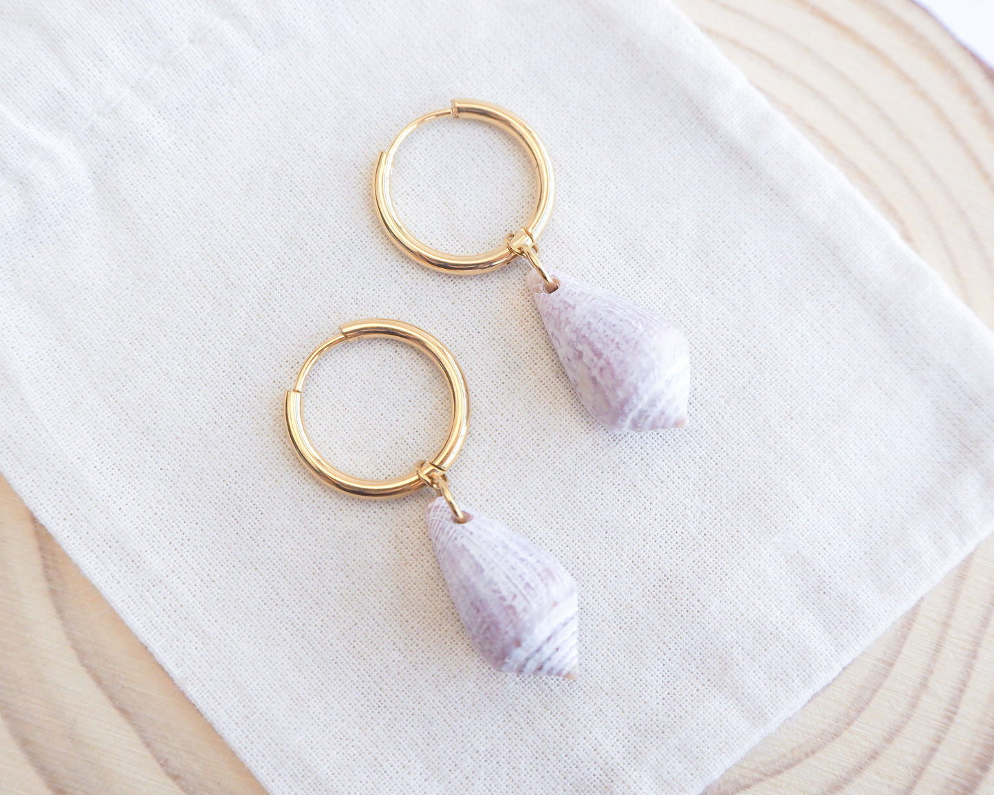 Close up of Light Mediterranean Cone Shell Gold Earring Hoops II on display, handpicked cone shells from Portugal, 18k gold stainless steel shell earring hoops, seabylou