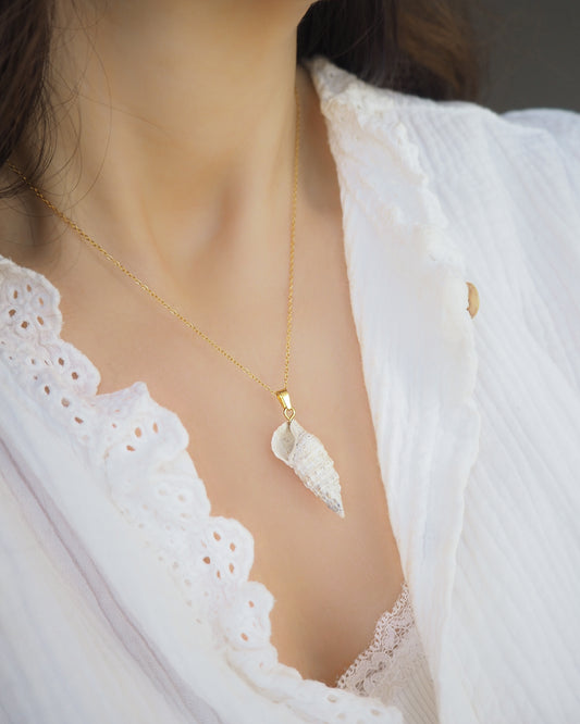 Model wearing Ivory Horn Shell Necklace on neck. Made with 18k gold stainless steel. Handpicked Shell from Portugal