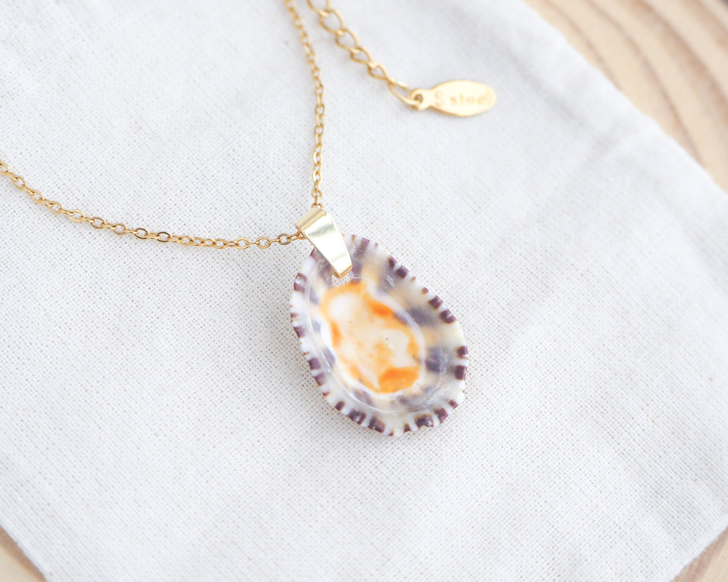 Front view of Gold Limpet Shell Upside Down Necklace with orange center on display. Limpet Shell from Portugal, Lapa Concha