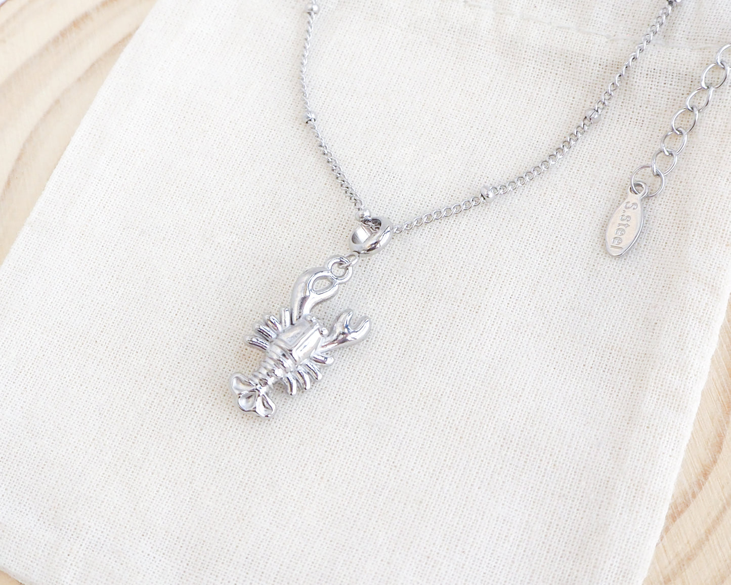 Silver Lobster Necklace on stone displayed, made with 18k gold stainless steel, coastal jewelry from Portugal
