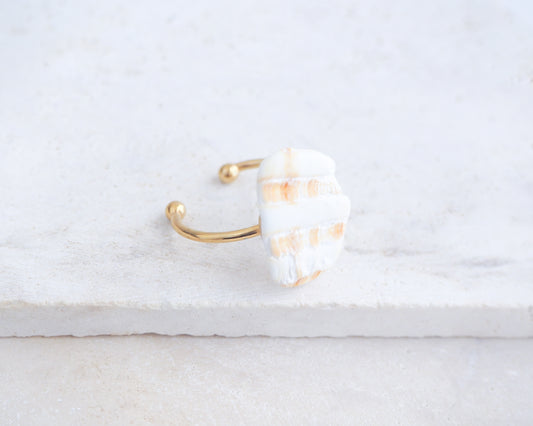 Side view of Mediterranean Cockle Shell Piece Gold Ring from Portugal on stone displayed, beach surf girl jewelry, gold ring with Portuguese cockle shell, ocean inspired beach jewelry, sunny yellow orange shell from Algarve