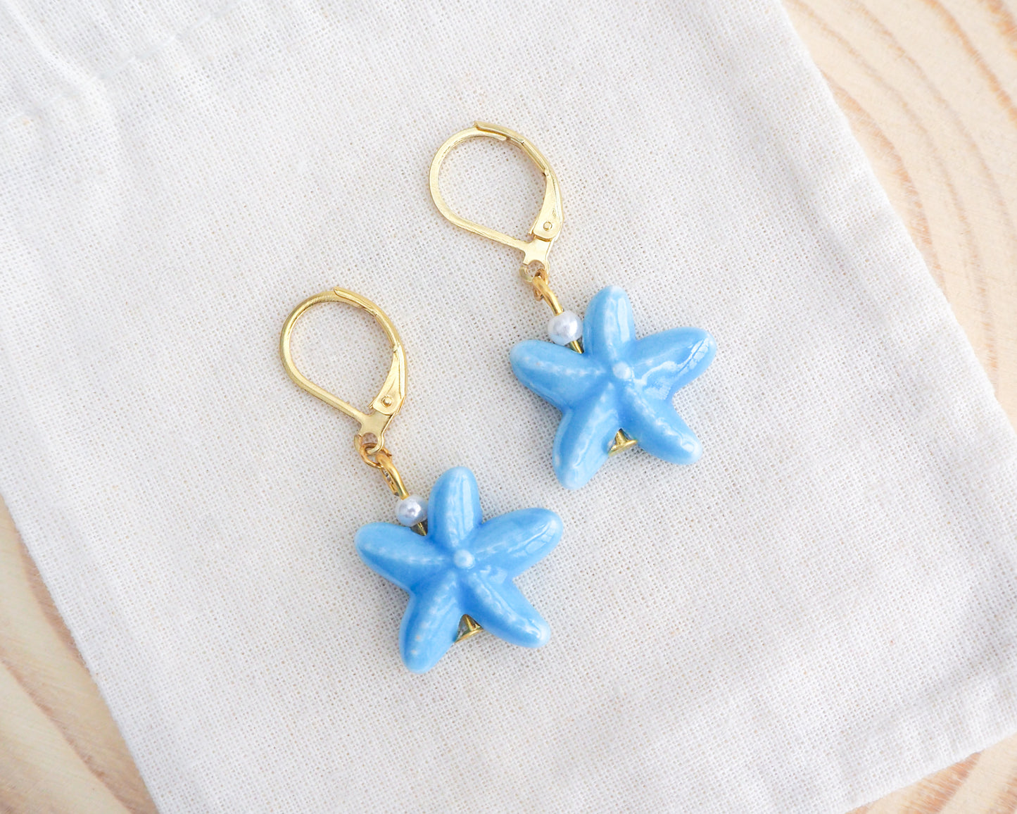 Mid Blue Starfish Ceramic Earrings on display