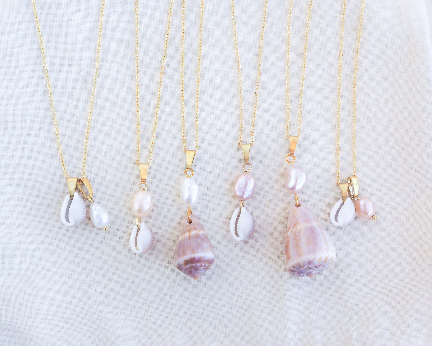 Front view Pearl Cone Shell and Cowrie Shell Pearl Necklaces on display