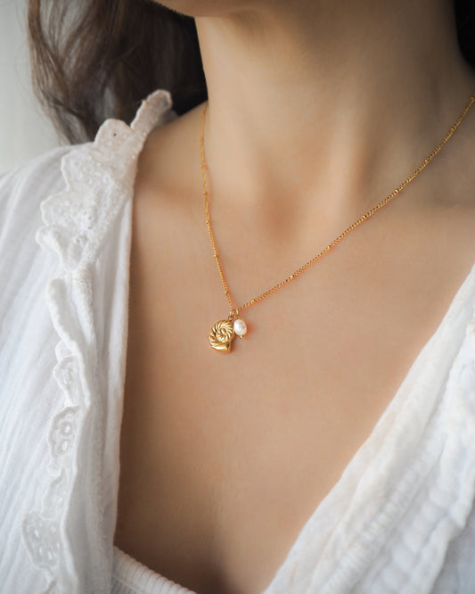 Model wearing Tiny Nautilus Seashell Pearl Necklace on neck, Gold Necklace with freshwater pearls and 18k gold nautilus seashell pendant, ammonite pendant, Minimalistic Ocean Inspired Jewelry, Jewelry for Beach Girls