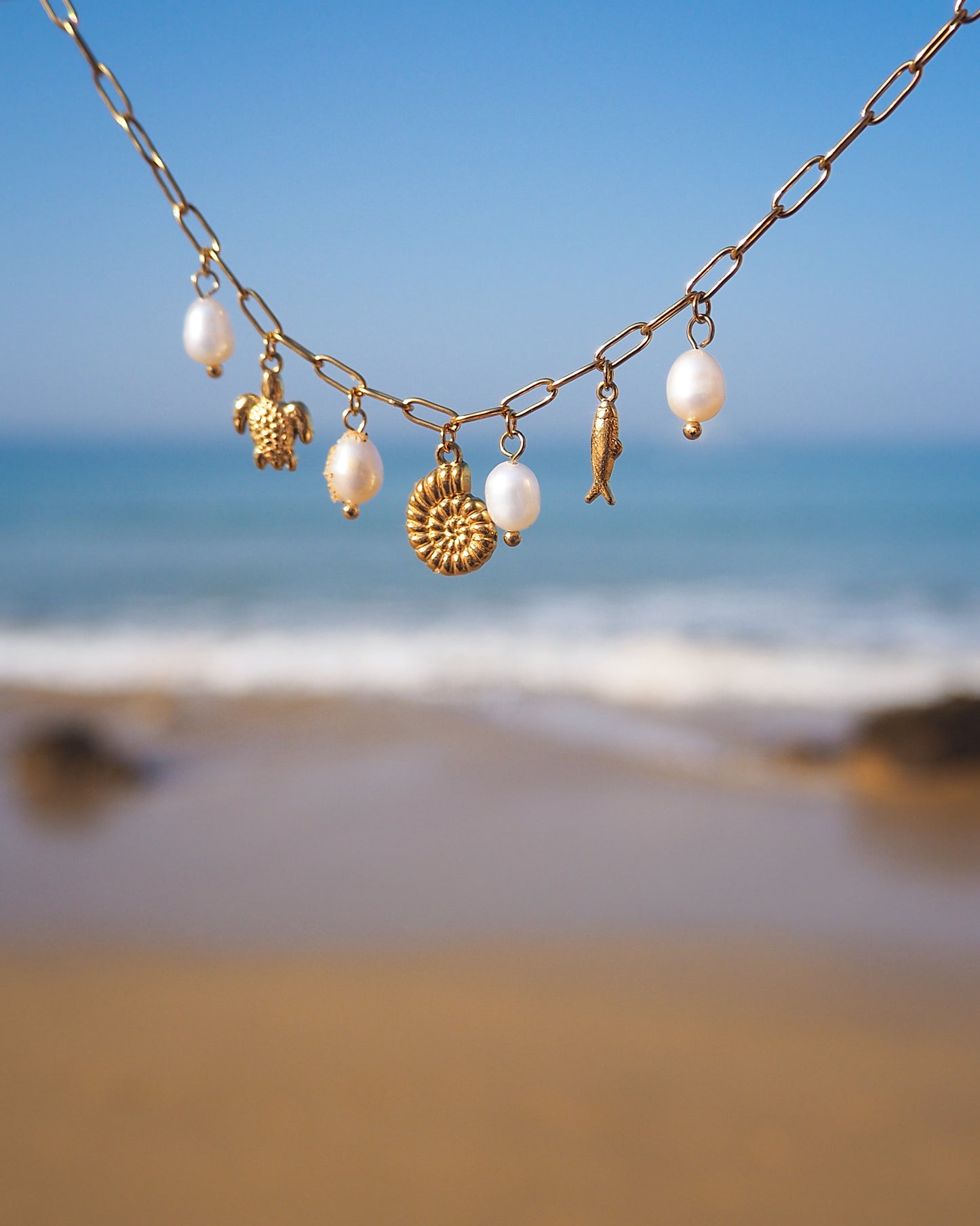 Gold Ocean charm bracelet with sea view background, made with freshwater pearls and ocean charms, 18k gold stainless steel bracelet with turtle, sardine, nautilus, Handmade nautical bracelet with ivory pearls, Coastal jewelry gold bracelet with sea charms, Ocean inspired bracelet with pearls and gold charms, Perfect gift for Christmas