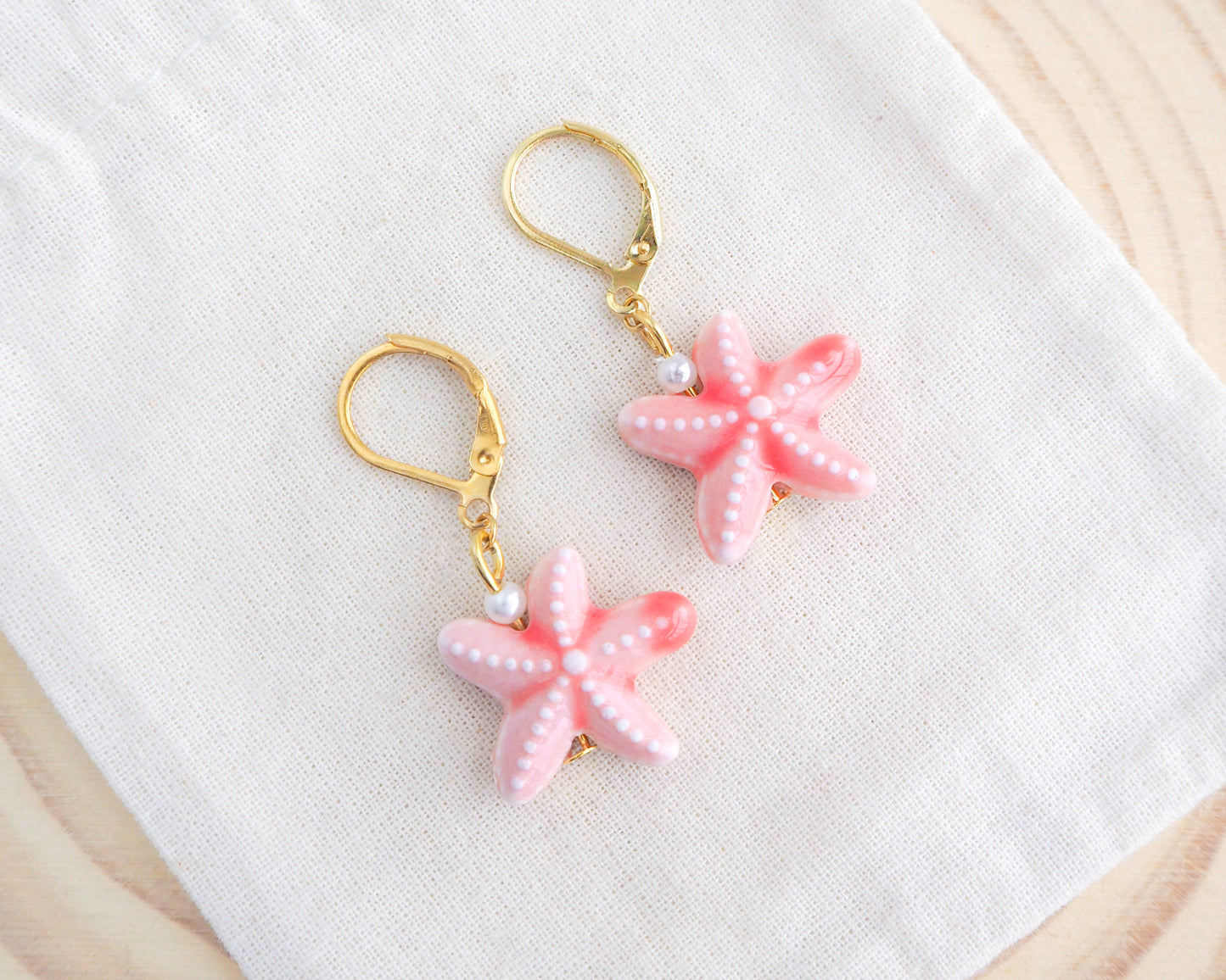 Pink Coral Starfish Ceramic Earrings on display
