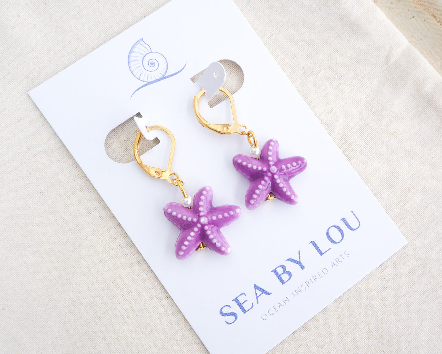 Purple Sea Star Ceramic Gold Earrings on display