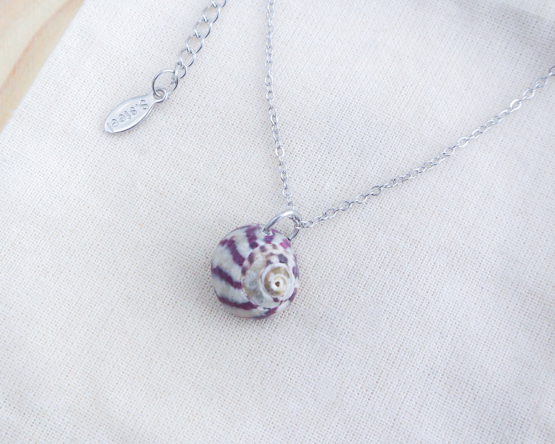 Purple Striped Top Shell Silver Necklace on display