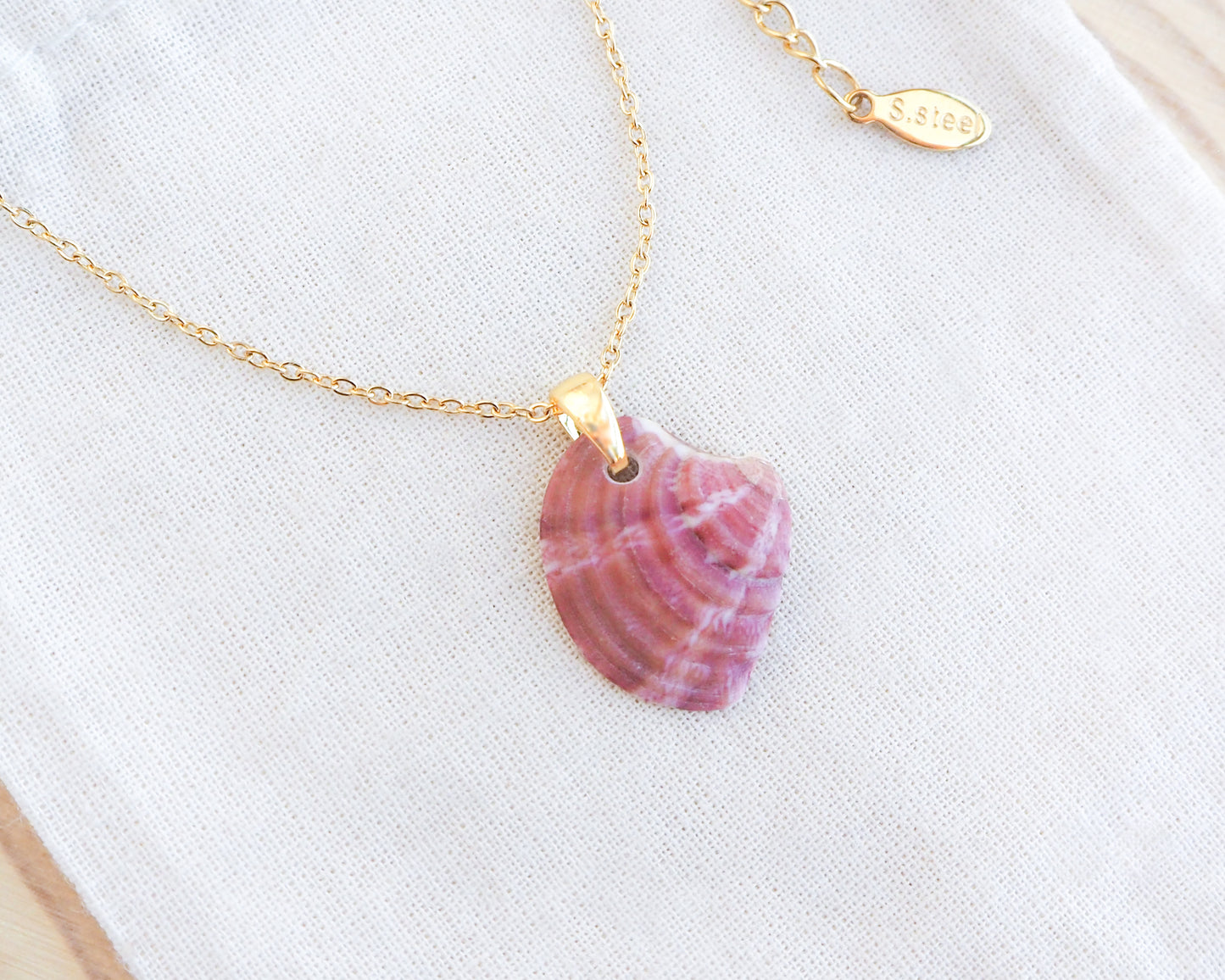 Raspberry Fuchsia Venus Shell Gold Necklace on display