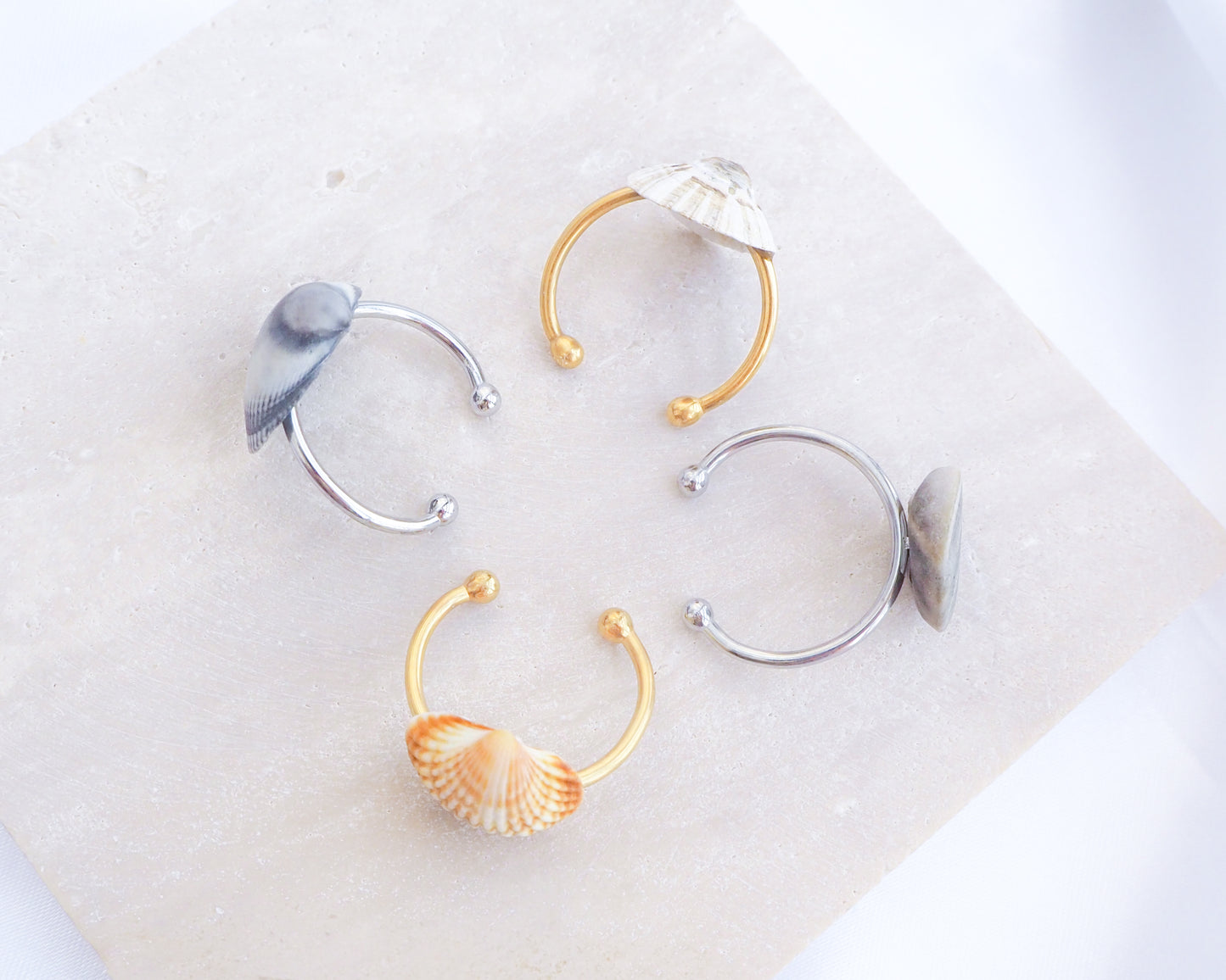 Front view of Seashell Adjustable Rings in gold and silver stainless steel on display