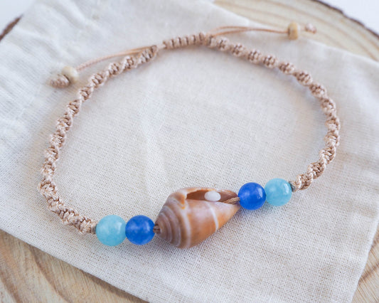Close-up of Cone Shell Bracelet with Gold Braided Cord and Aquamarine Beads