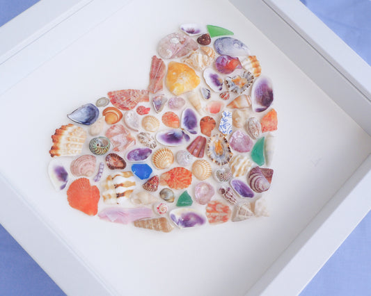 Framed artwork made of colorful seashells on a white background. Close up of Rainbow Seashell Heart Artwork with colorful shell handpicked from Portugal. Coastal Home Wall Decor, Shell Wall Art, Handmade Shell Artwork, Cute Coastal Nursery Decoration