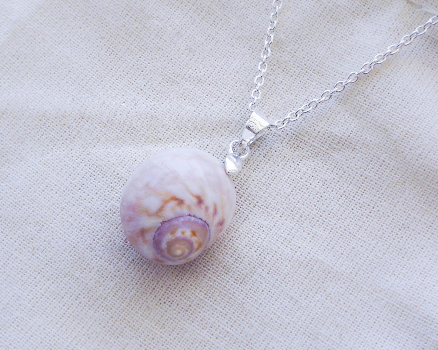 A close-up image of the Moon Shell Silver Pendant, showcasing its intricate details and elegant design, coastal ocean inspired jewellery, sea by lou