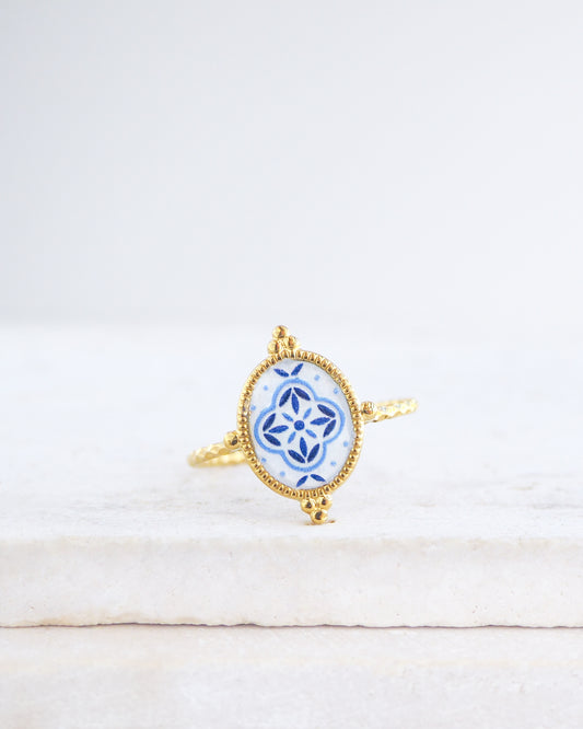 Blue Portuguese Tile Oval Rings on stone displayed. The ring is handmade with 18k gold stainless steel and are made with different patterns inspired by the Portuguese azulejos tiles.