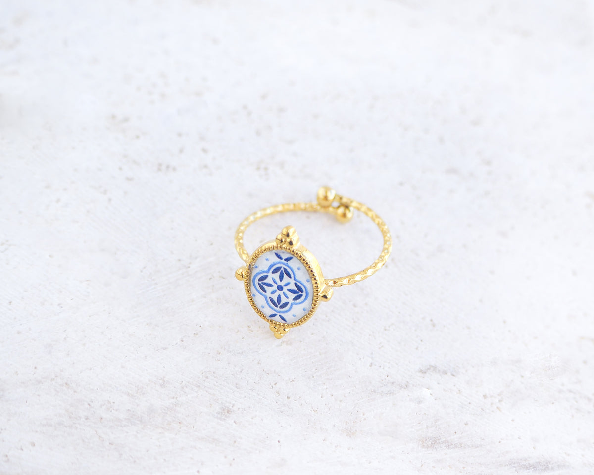 Side view of Blue Portuguese Tile Oval Rings on stone displayed. The ring is handmade with 18k gold stainless steel and are made with different patterns inspired by the Portuguese azulejos tiles.