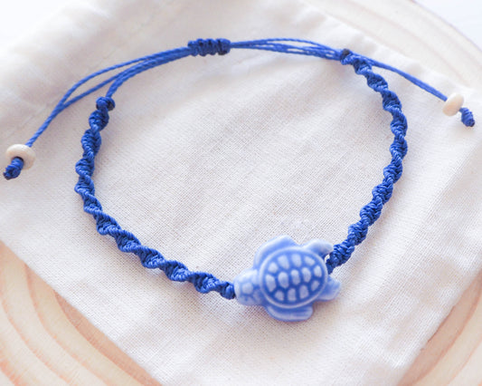 A close-up photo of the Deep Blue Ceramic Turtle centerpiece. The turtle is handcrafted with intricate detailing and glazed in vibrant deep blue, sea by lou, portugal jewelry