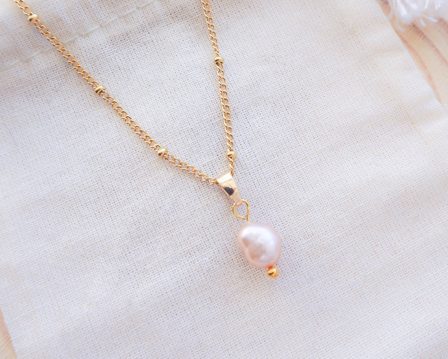 Close up of Sea by Lou Gold Necklace with rose color freshwater pearl pendant