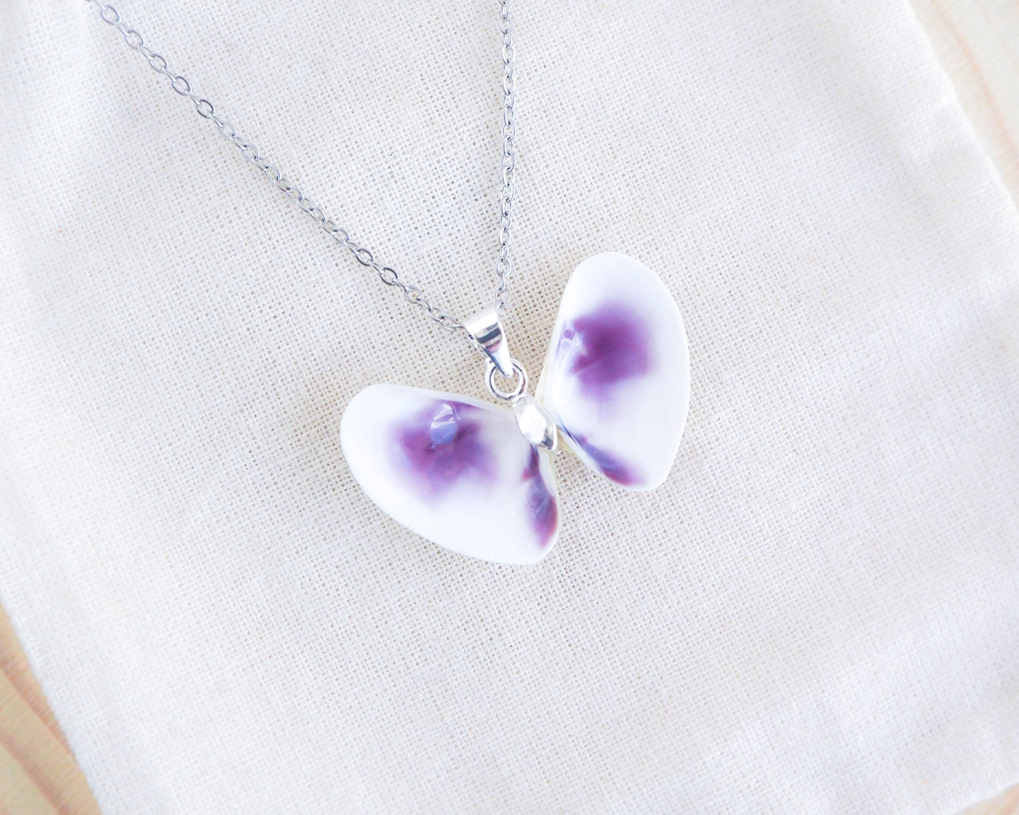 Purple Coquina Shell Butterfly Silver Necklace on display