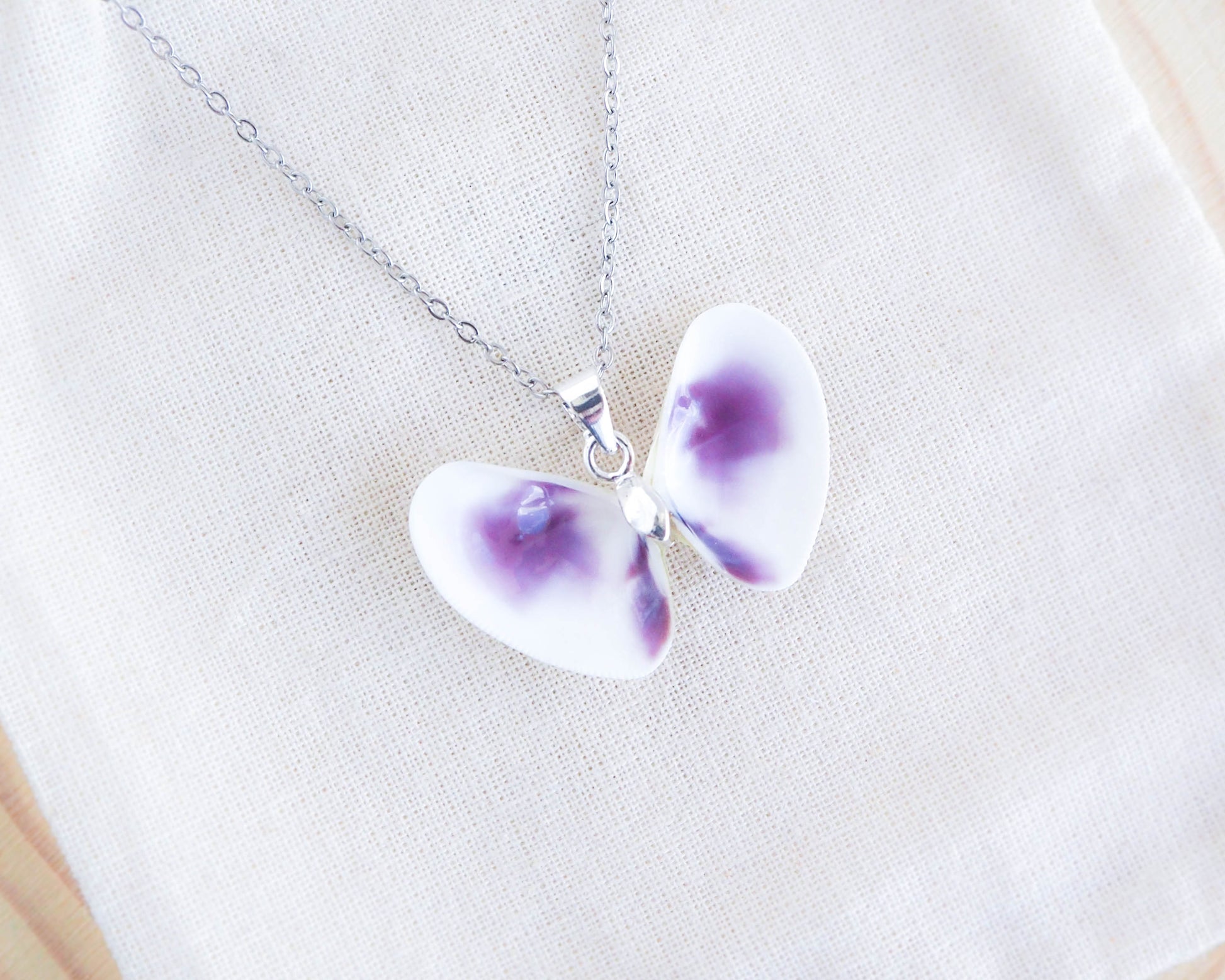 Purple Coquina Shell Butterfly Silver Necklace on display